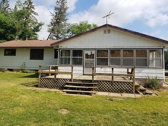 Back of the home with deck and large 3 season porch. Deck is in the process of being pressure washed and stained.