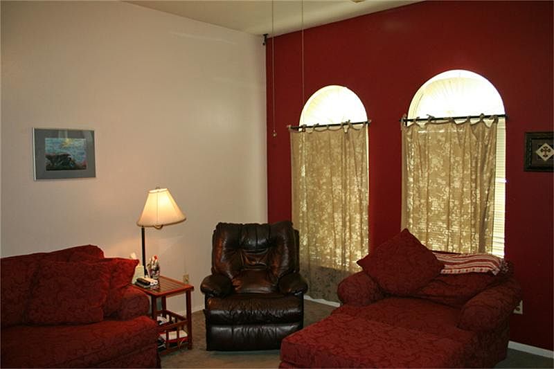 Pretty family room features arched windows, accent wall and is open to the dining and kitchen.