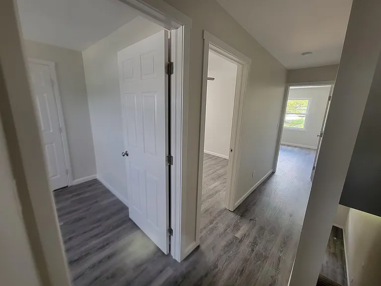 Upstairs hallway opens to three bedrooms and bathroom.