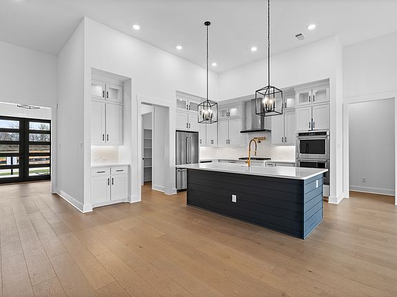 The kitchen has gorgeous white cabinetry with black hardware.