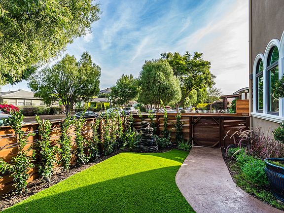 Private front yard with artificial lawn, fountain and hedges