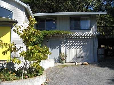 Apartment with main house to the left, large deck and under deck parking to the right.