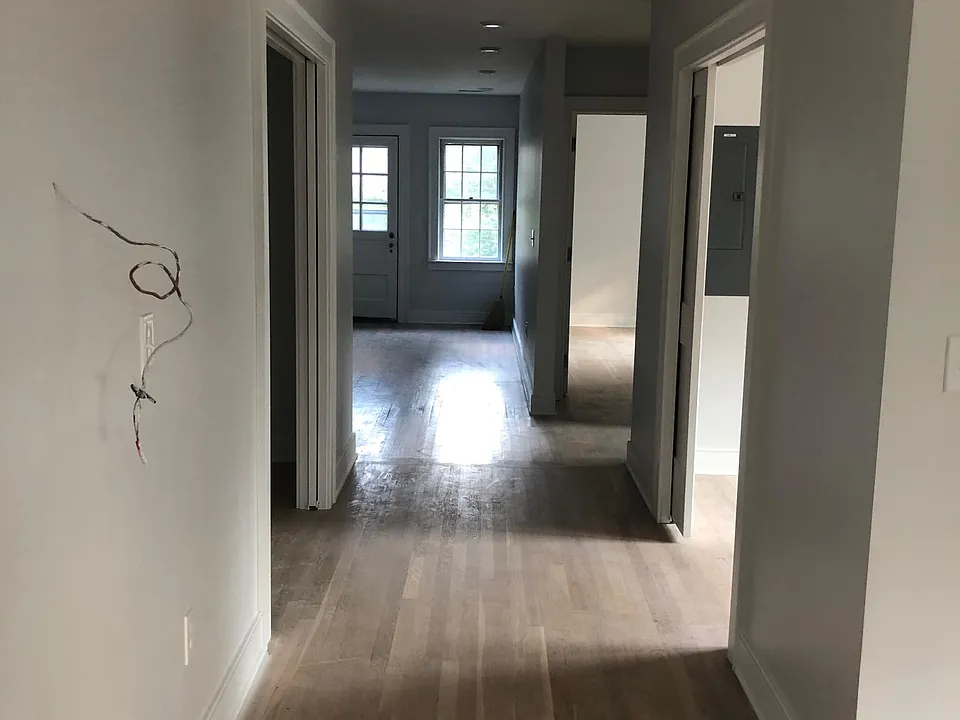 This hallway leads to the back of the house. The wires on the left side of hallway are where the Nest thermostat lives now. That open space farther along on the left wall is an enormous closet. On the right side of the hall is a bonus room. It can't le