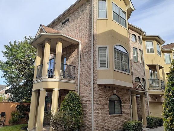 Side view of home showing the first floor covered porch, second floor balcony off the living room. Note the balcony off the kitchen/den area.