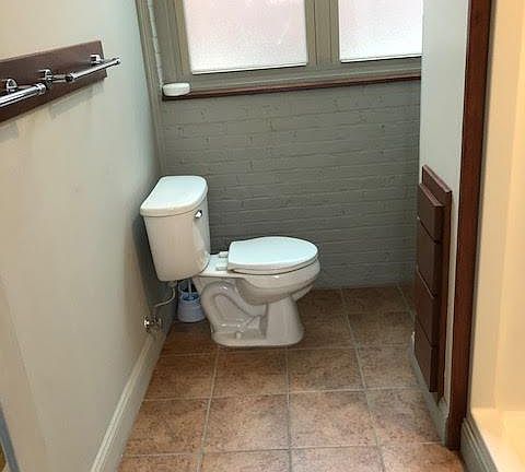 The tiled bath has a shower and several built-in amenities.