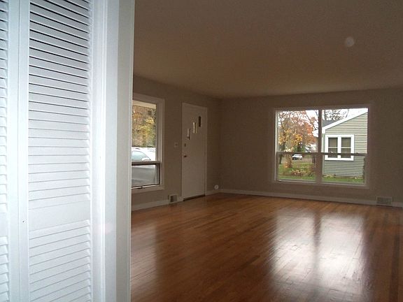 Living room 1 with hardwood floors and large windows.