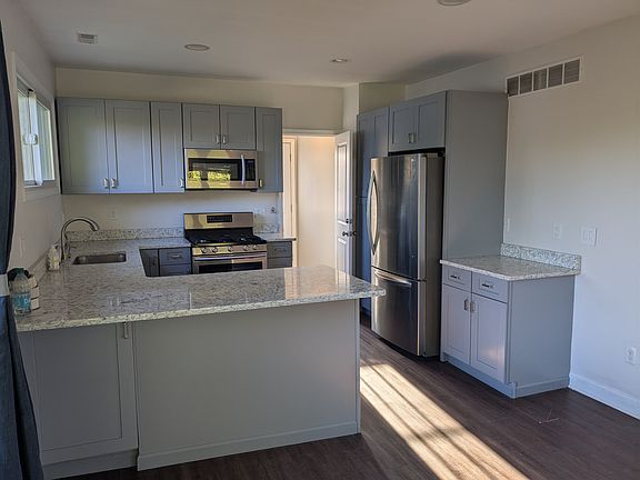 Kitchen with quartz countertops and stainless steel appliances. Gas stove.