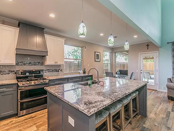 Updated full kitchen with granite countertops, open space with an island which includes bar seating and stainless steel farm sink.
