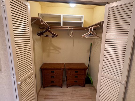 Walk in closet with dresser drawers and shelving
