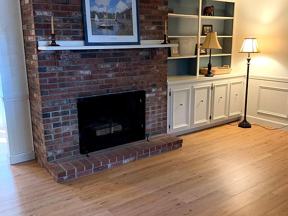 Family room with working fireplace. Built-ins and wainscoting show the attention to detail.