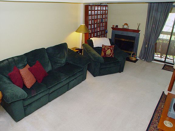 Living room w/wood burning fireplace and sliders to private balcony
