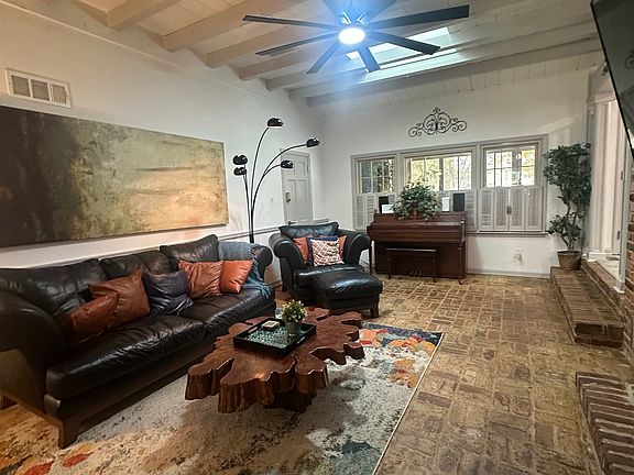 Rustic charm meets modern comfort _ exposed brick, cool breeze, and a 60-inch view of relaxation.