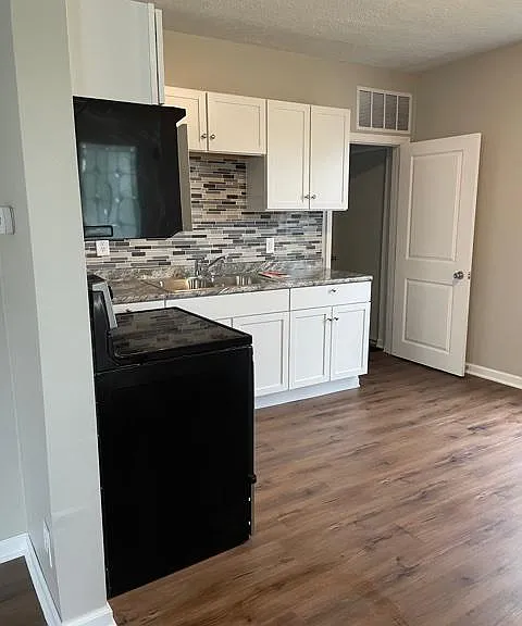 Eat-in kitchen with overhead microwave and electric range.