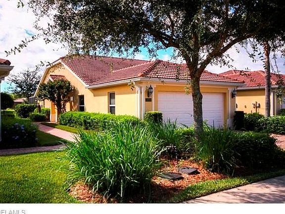 Beautiful landscaping surrounds 2 car garage villa