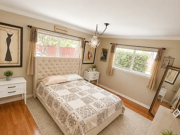 Second bedroom with hardwood floors, crown molding, fresh paint, large windows, and large closet.