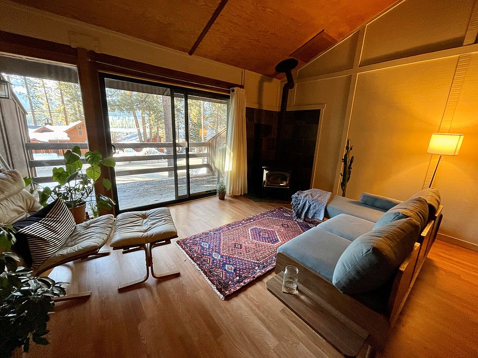 Living room with hardwood floors and vaulted ceiling.