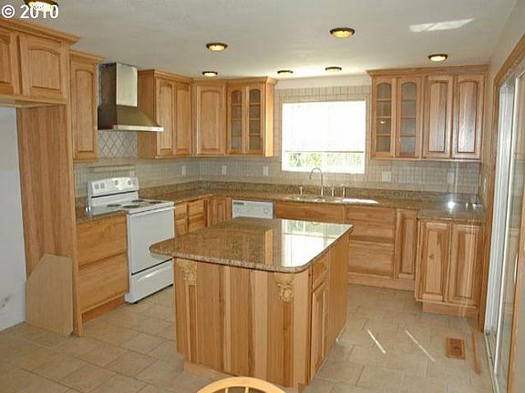 This BEAUTIFUL kitchen features slab granite, hickory custom cabinets and Italian tile backsplash an