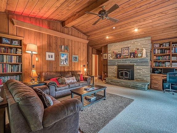 large family room with a wood burning fireplace, vaulted ceiling, built in bookshelves.
