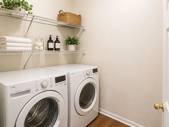 Convenient in-home laundry room with full-size washer and dryer connections, built-in shelving, and extra space to keep laundry organized.