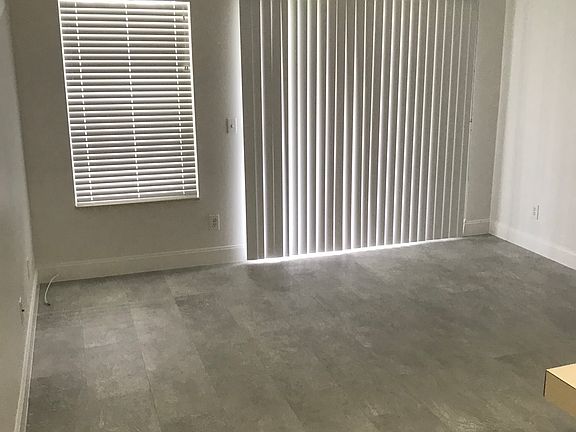 Living room looking towards balcony sliders and window.