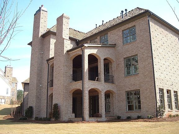 Two covered fireplace porches overlook the level and private back yard