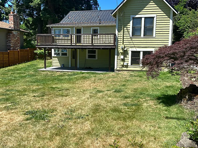 enormous level fully fenced private back yard with a large deck and lower patio