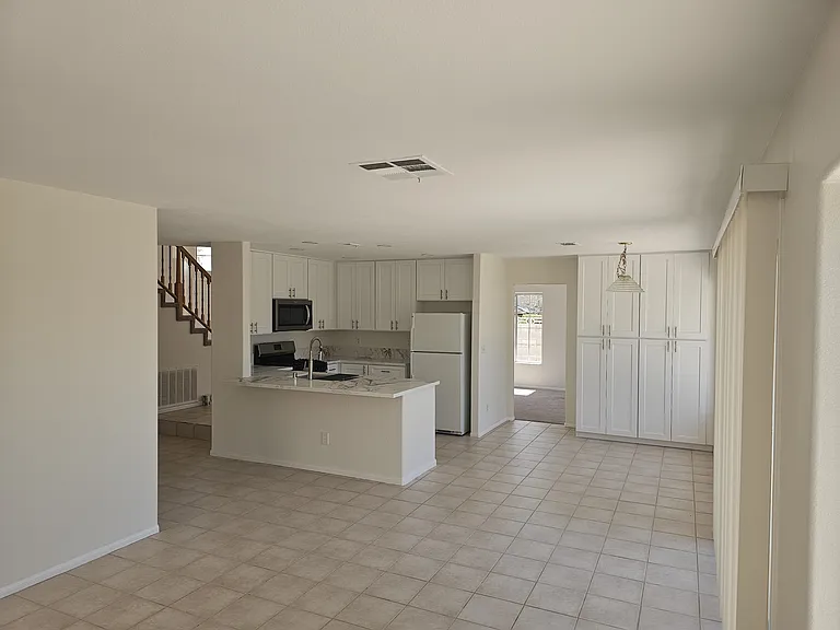 A welcoming kitchen offers white cabinetry, modern appliances, and a convenient breakfast bar.