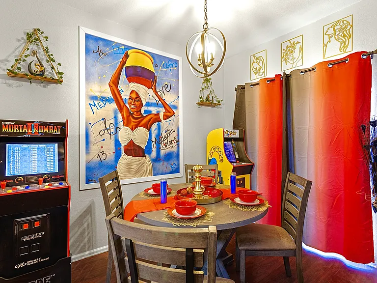 Fun and vibrant dining area with a retro arcade game and colorful decor. Perfect for family meals and game nights.