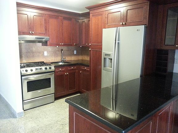 Photo of the kitchen with full size refrigerator, range and dishwasher.