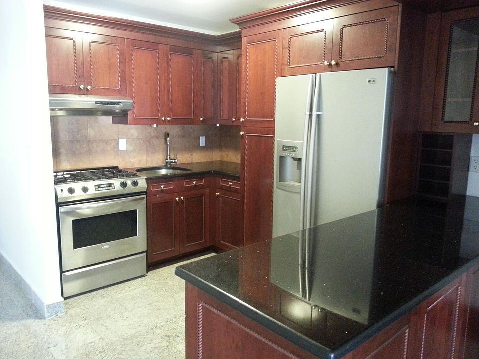Photo of the kitchen with full size refrigerator, range and dishwasher.
