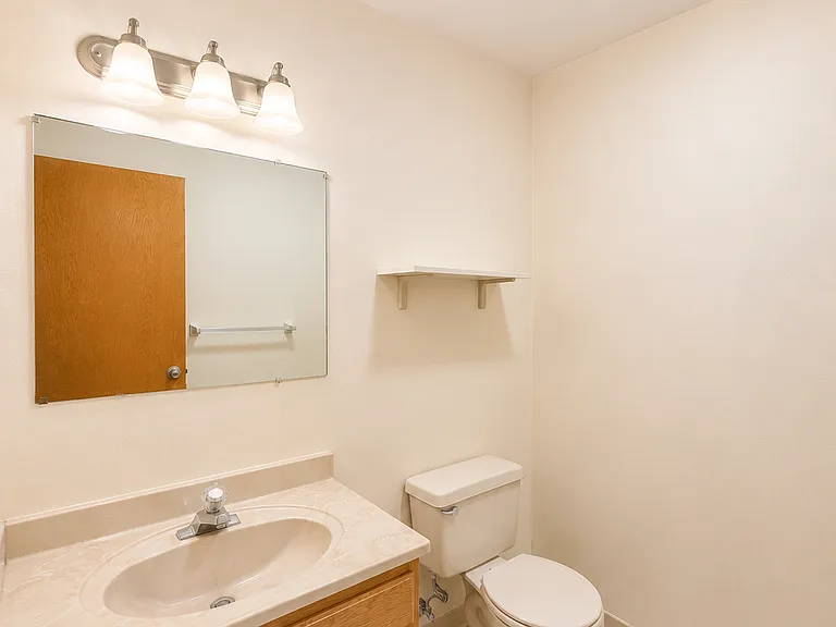 Well-maintained bathroom with vanity and storage shelf