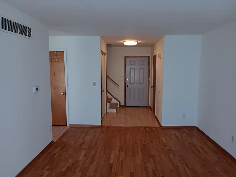 Living area with half bath and large main entrance, smoke detector, large basement access with laundry facilities and central AC gas heating equipment. Basement is sectioned for study area/office with door.