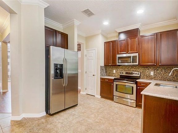 Wood cabinets, solid surface countertops, mosaic backsplash and stainless appliances