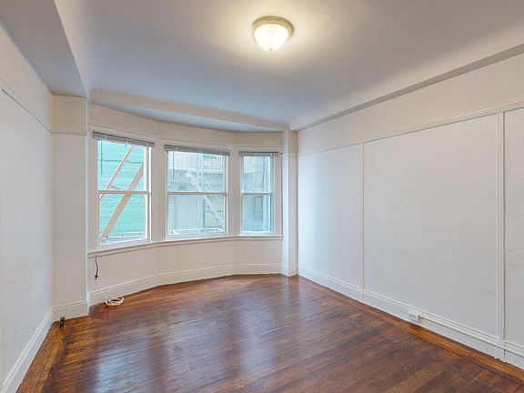 Living room with wood-like floors and a large window