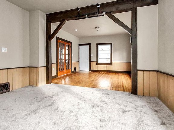 This is a pic of the front door (white) and the French doors that lead to master bedroom. The hardwood floors could be a living room or the carpeted area could be either a living or dining room.