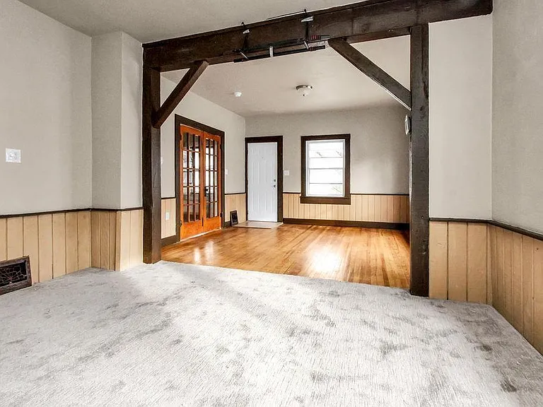 This is a pic of the front door (white) and the French doors that lead to master bedroom. The hardwood floors could be a living room or the carpeted area could be either a living or dining room.