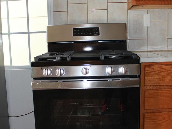 Stainless steel gas stove with range hood.