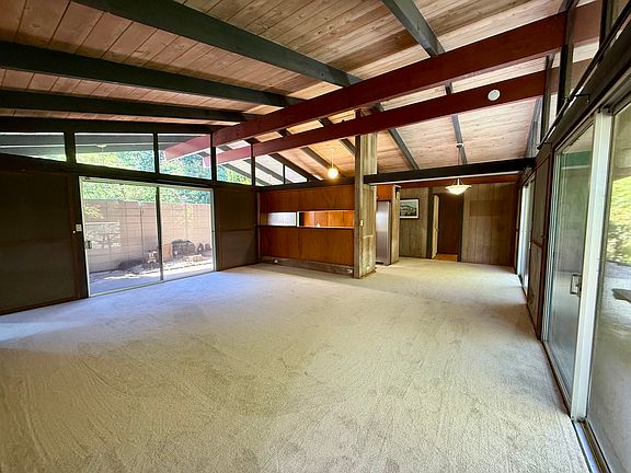 Spacious living area with high-ceilings and brand-new carpet.