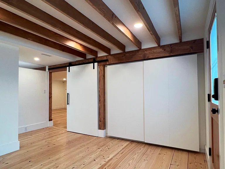 3rd bedroom with exposed wood ceiling, barn sliding door, large closets and direct access to back yard.