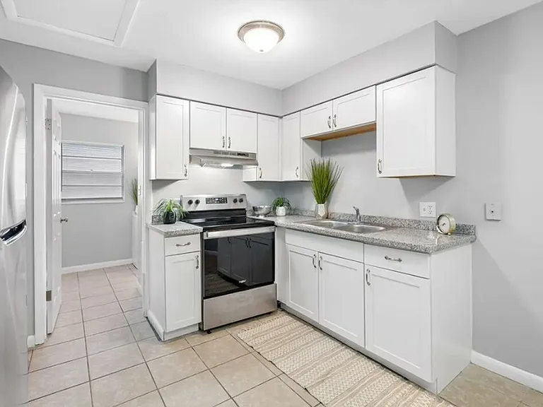 Modern kitchen with sleek stainless steel appliances, elegant white cabinetry, and stylish granite countertops.