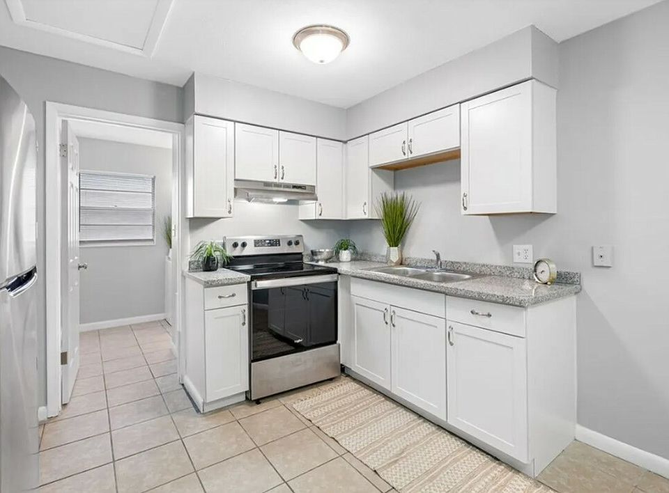 Modern kitchen with sleek stainless steel appliances, elegant white cabinetry, and stylish granite countertops.