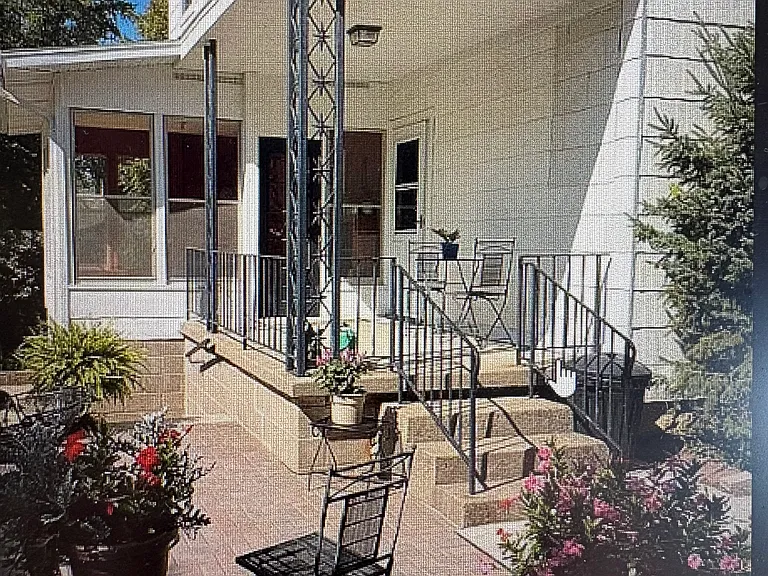 Glider rocker on the back porch. Patio table with umbrella included on the paved patio.
