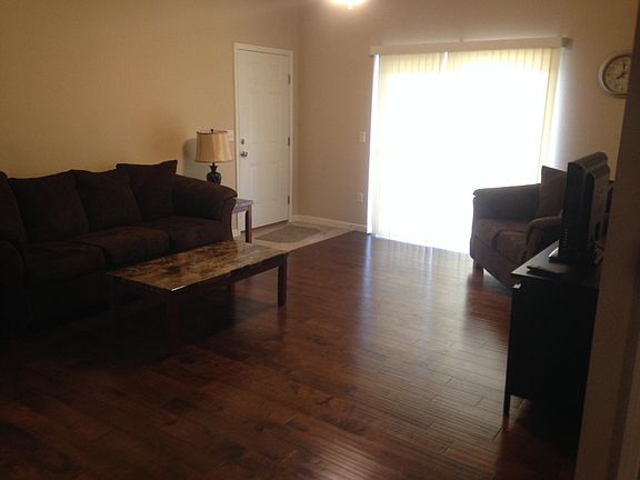 Large well lit living area with hardwood floors