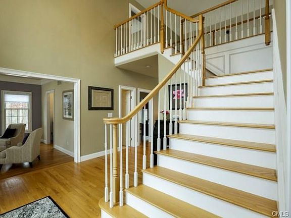 Sweeping staircase with picture framing molding leads to 4 spaci