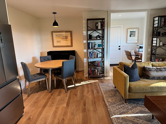 View of dining area from kitchen, looking back into living room, entry/mud room, and main entry door