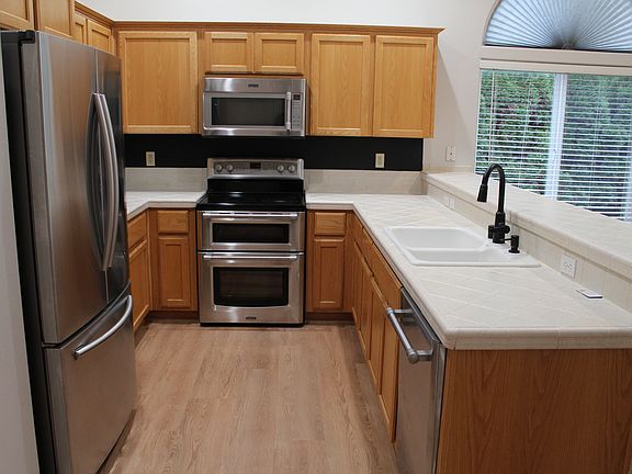 Kitchen with all stainless steel appliances and tile countertop