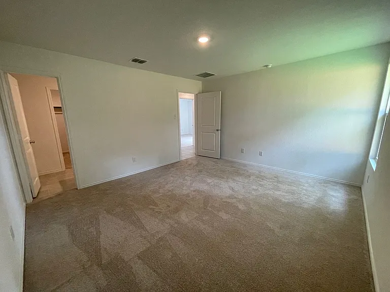 Primary bedroom showing entry door and bath.