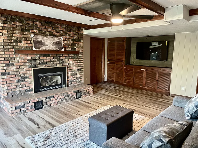 Large brick fireplace statement in the lower-level seating area.