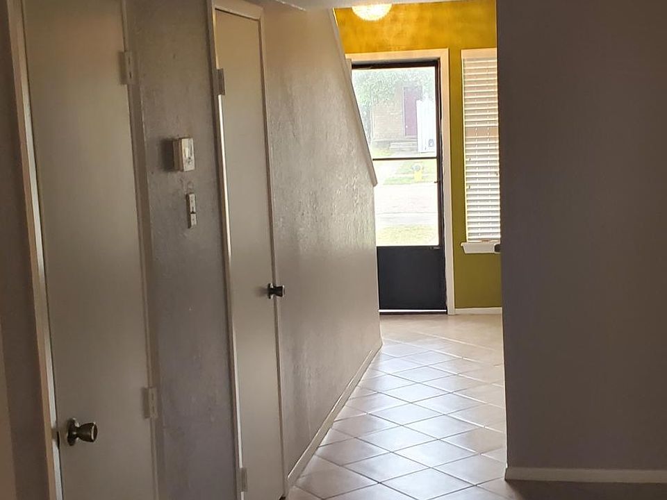 View from living room area to front entry . Air conditioner room on left and then large closet storage on left has built in desk area was used as a computer nook by previous tenant.