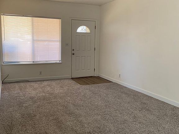 Spacious living room upon entry with lush carpeting.